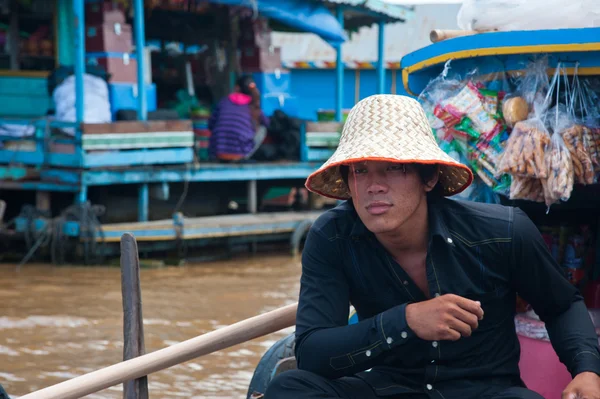 Asian boy sitting in the boat and selling some souvenirs — Stock Photo, Image