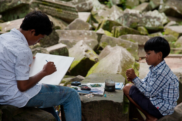 Азиатские мальчики рисуют картину
