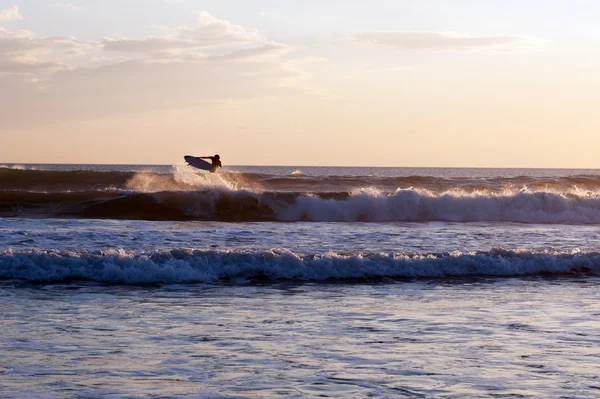 Surfař při západu slunce v oceánu — Stock fotografie