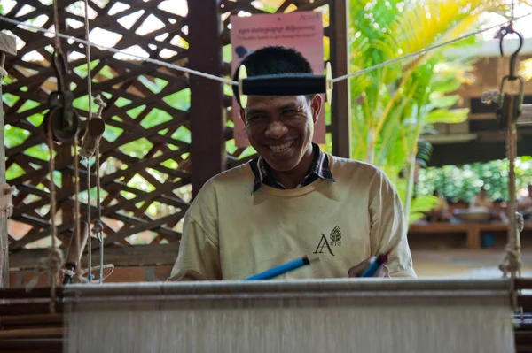 Weaver adjusts the silk cloth on his loom — Stock Photo, Image