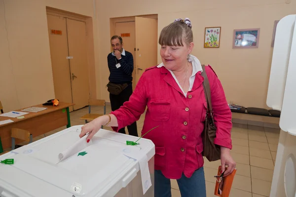 Vrouw zetten verkiezing stemming met kandidaten voor de burgemeester — Stockfoto