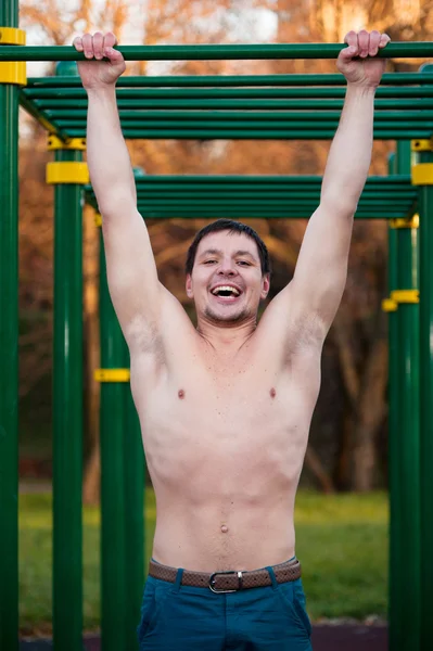 Athlete doing pull-up on bar — Stock Photo, Image