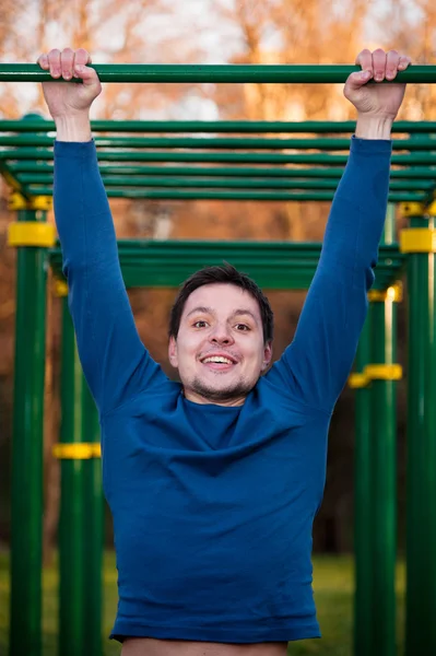 Idrottsman gör pull-up på vågräta fältet — Stockfoto