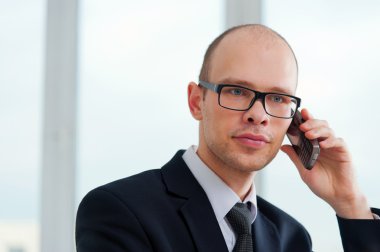 Office telefonda konuşurken gözlüklü genç işadamı