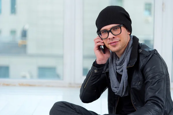 Mladý usmívající se muž mluví po telefonu — Stock fotografie