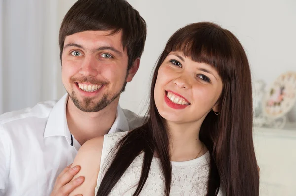 Sonriente hombre y mujer se encuentra en el interior del hogar — Foto de Stock