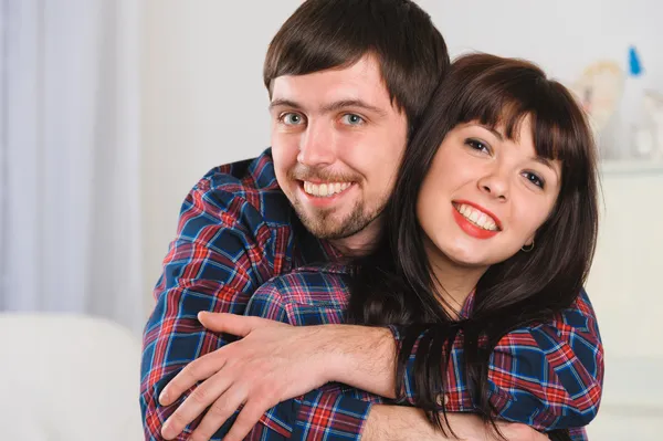 Portrait of young smiling couple at home interior — Stock Photo, Image