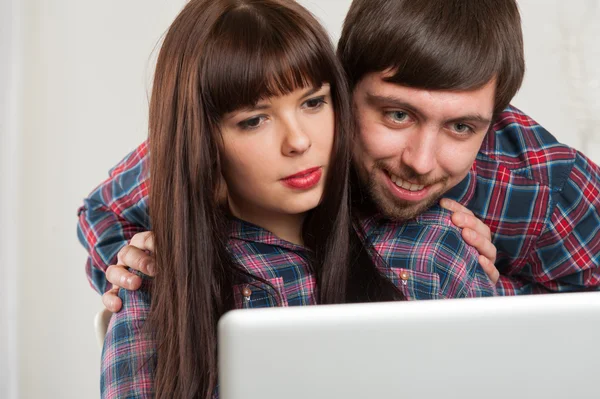 Молодая пара использует ноутбук дома. Портрет крупного плана — стоковое фото