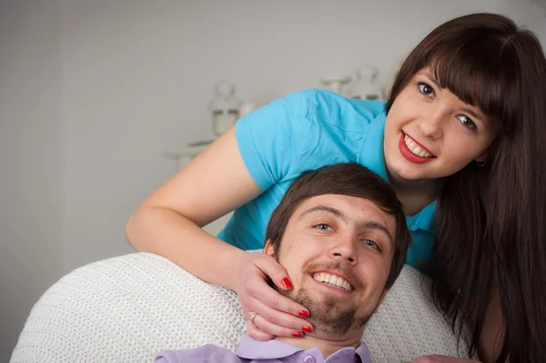 Junge hübsche Frau umarmt ihren Freund auf der Couch — Stockfoto