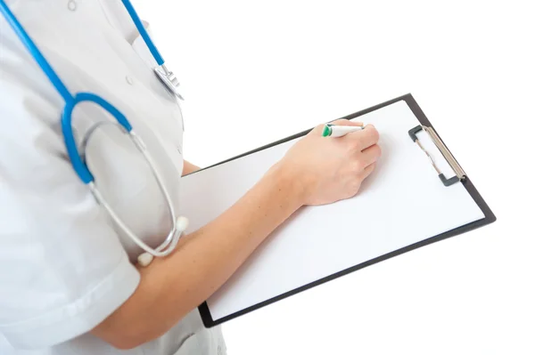 Vrouwelijke arts schrijven op lege Klembord — Stockfoto