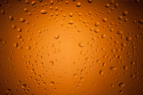 Gotas de agua sobre vidrio con fondo naranja — Foto de Stock