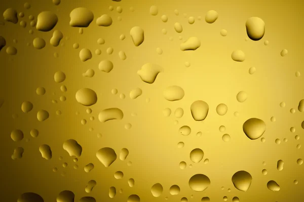 Yellow gold water drops on glass surface — Stock Photo, Image