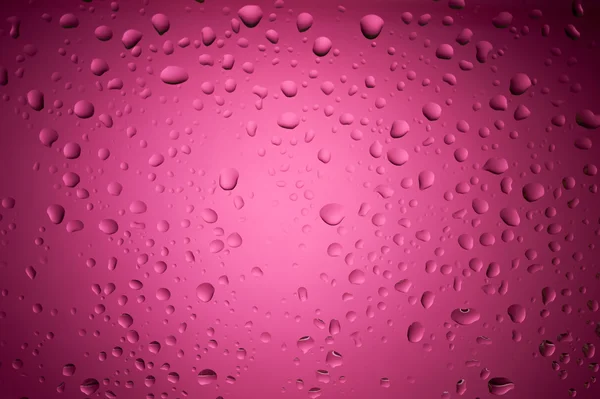 Gotas de agua púrpura sobre vidrio — Foto de Stock