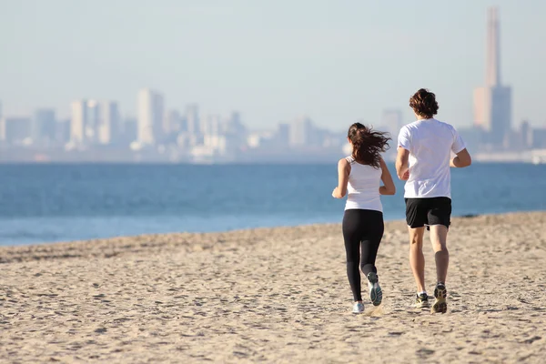 Mann und Frau rennen am Strand — Stockfoto