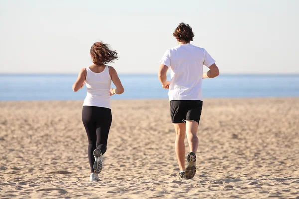 Homem e mulher correndo na praia — Fotografia de Stock