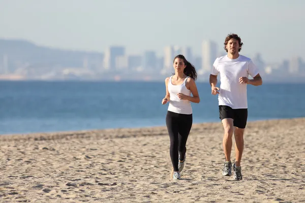 Hombre y mujer corriendo en la playa —  Fotos de Stock