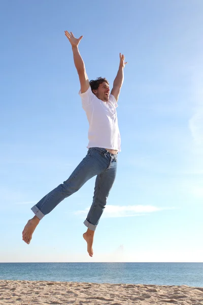 Mann springt glücklich in den Strand — Stockfoto