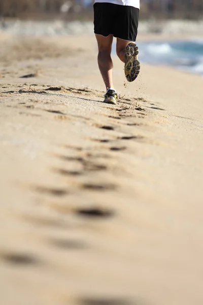 Männerbeine laufen auf dem Sand eines Strandes — Stockfoto