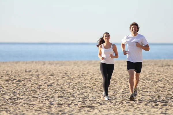 Uomo e donna che corrono in spiaggia — Foto Stock