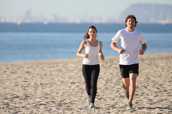 Hombre y mujer corriendo en la playa —  Fotos de Stock