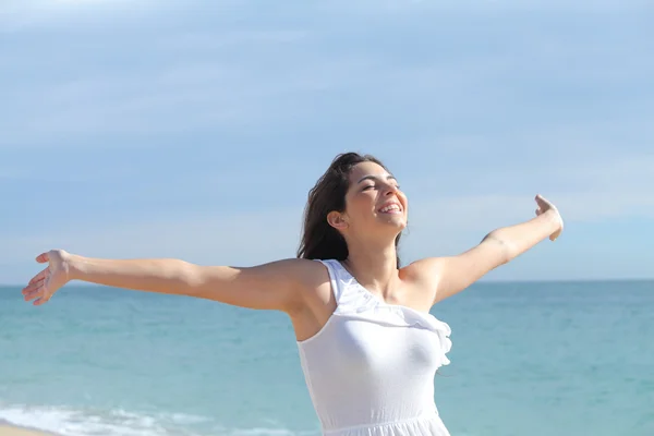 Vacker flicka med armarna upp på stranden — Stockfoto
