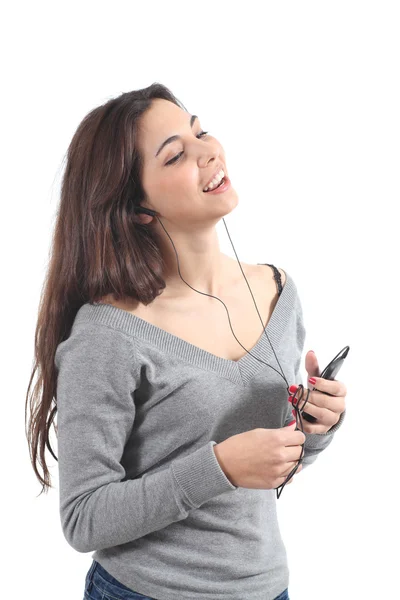 Vacker kvinna sjunger och lyssnar på musik med hörlurar — Stock fotografie