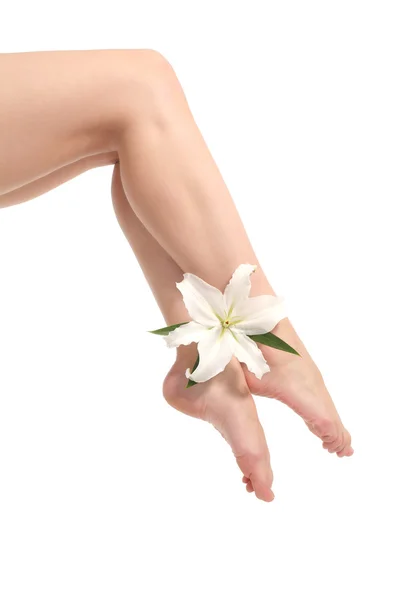 Belle femme jambes avec chevilles croisées avec une fleur blanche — Photo
