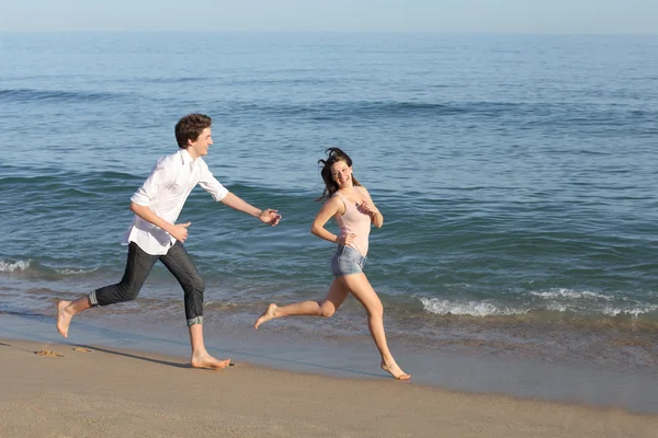 Coppia che gioca e corre sulla spiaggia — Foto Stock