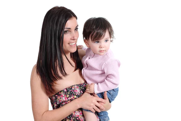 Atractiva madre sosteniendo a su hija bebé y mirando a su lado — Foto de Stock