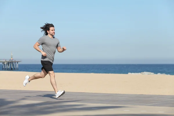 Young sportsman running on the seafront of the beach — Stock Photo, Image