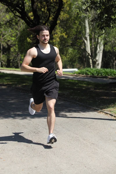 Спортсмен бегает по парку — стоковое фото