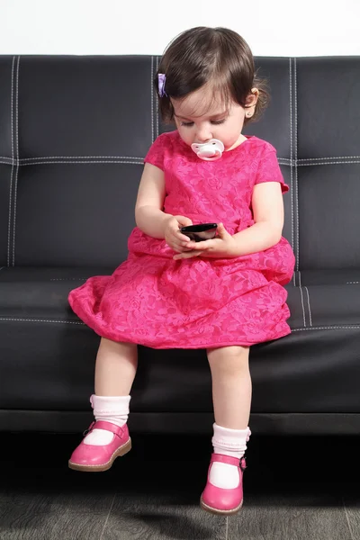 Belo bebê brincando com um telefone inteligente em casa — Fotografia de Stock