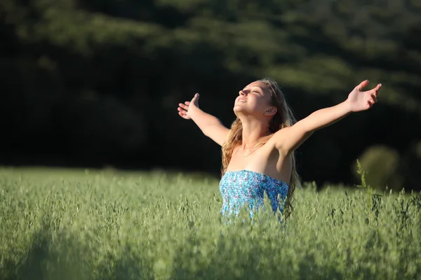Krásné dospívající dívka dýchá radost na zelené louce — Stock fotografie