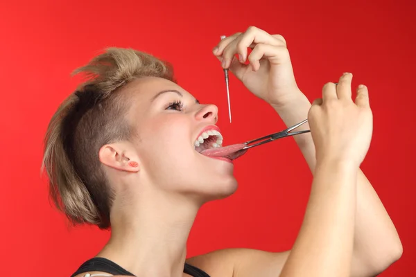 Kvinna piercing tungan själv — Stockfoto