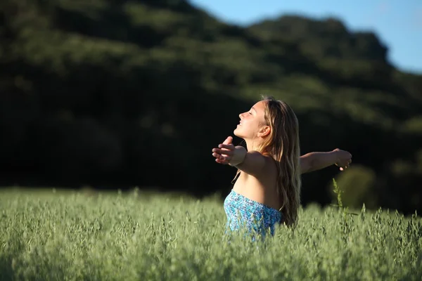 Hermosa mujer respirando feliz en un prado verde —  Fotos de Stock