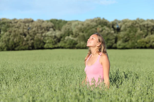 Beautiful casual woman breathing happy in a green meadow — Stock Photo, Image