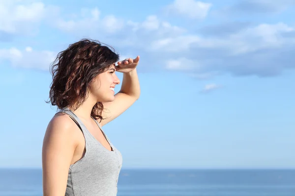 Hermosa mujer mirando hacia adelante con la mano en la frente — Foto de Stock