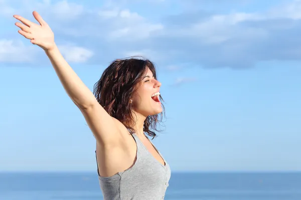 Mujer atractiva con los brazos levantados gritando al viento — Foto de Stock