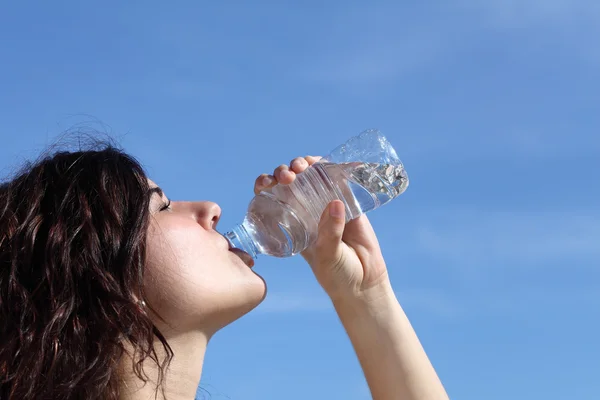 Profilo di una bella donna che beve acqua da una bottiglia di plastica — Foto Stock