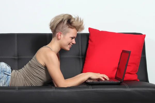 Fashion woman browsing internet in a laptop at home — Stock Photo, Image