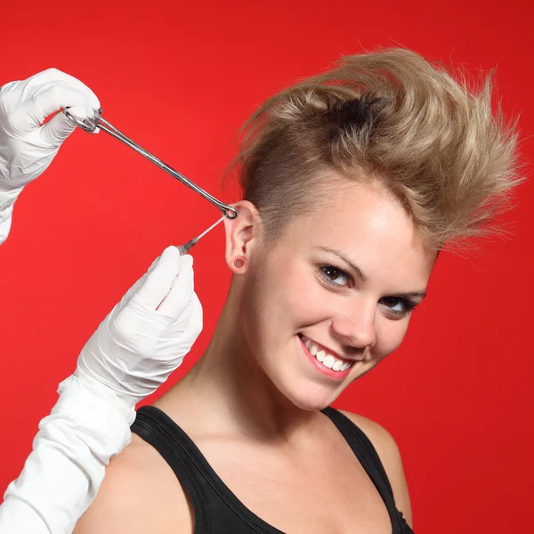 Mãos profissionais fazendo um furo para uma mulher de moda — Fotografia de Stock