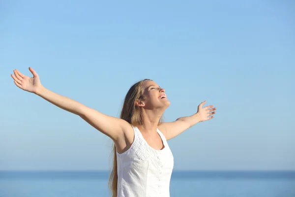 Schöne blonde Frau atmet glücklich mit erhobenen Armen — Stockfoto