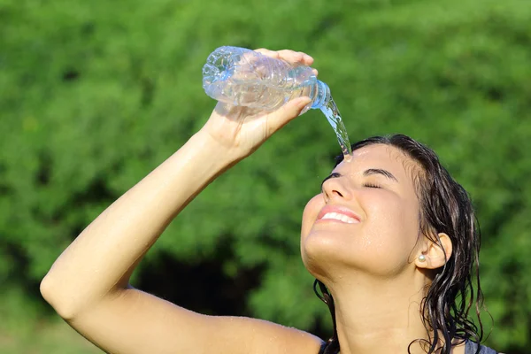 Donna attraente gettandosi acqua da una bottiglia — Foto Stock