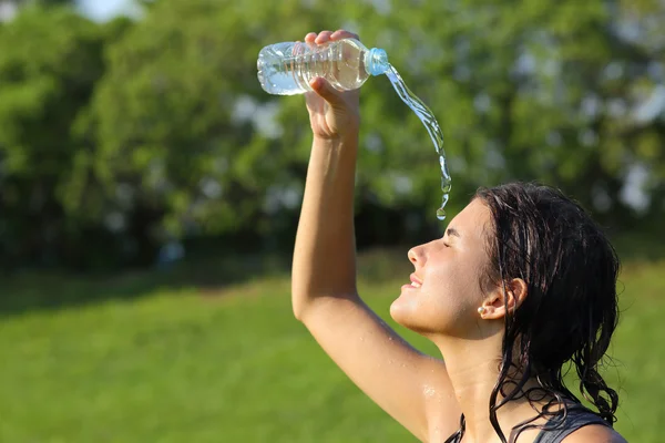 Belle femme se jetant de l'eau d'une bouteille — Photo