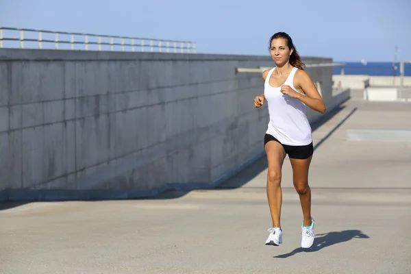 Atractiva mujer corriendo sobre el asfalto —  Fotos de Stock