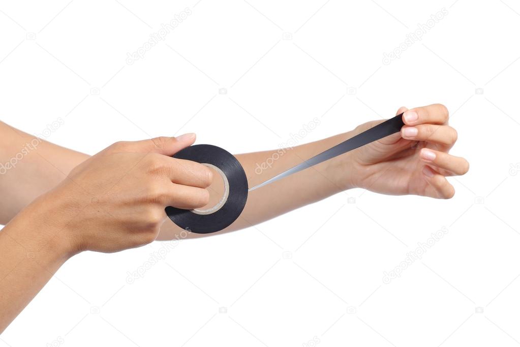 Woman hands holding and using an insulating tape