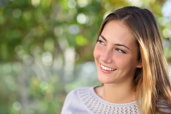 Krásná zamyšlená žena s úsměvem při pohledu nad venkovní — Stock fotografie