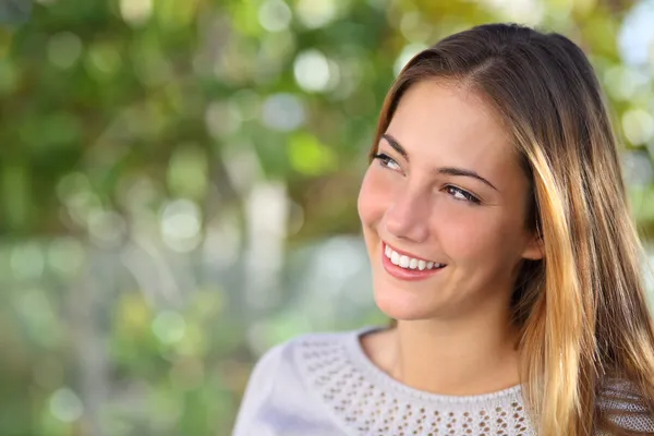 Beautiful pensive woman smiling looking above outdoor — Stock Photo, Image