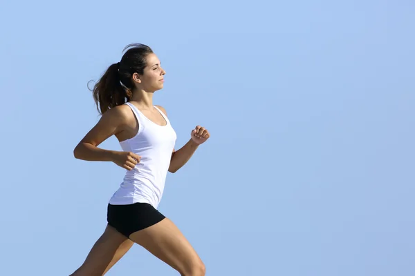 Vista lateral de una mujer corriendo con el cielo en el fondo —  Fotos de Stock