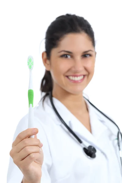 Piękne kobiece dentysta lekarz gospodarstwa i pokazano szczoteczka do zębów — Zdjęcie stockowe